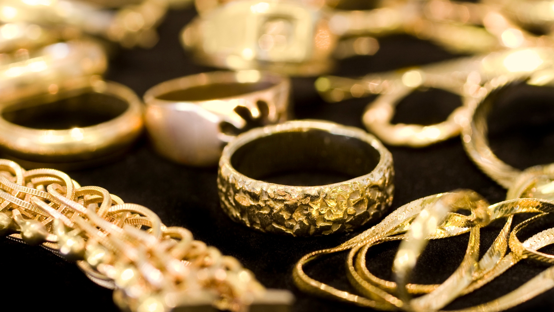 Geelgouden ringen en armbanden die bij elkaar liggen.